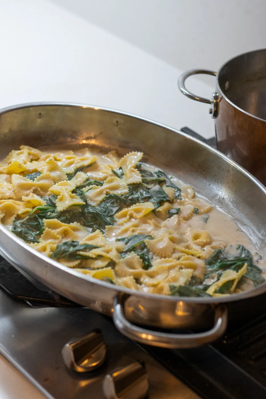 The pasta comes together with the sauce and the chard in the pan